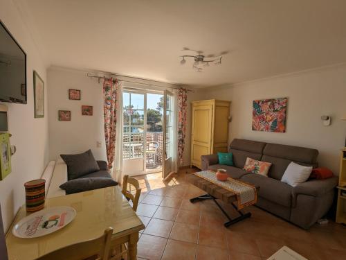 un salon avec un canapé et une table dans l'établissement L'Instant Plage - Vue Mer - Bord de Plage - La Capte - Côte d'Azur, à Hyères
