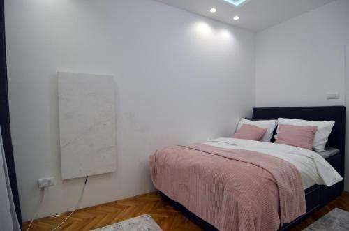een slaapkamer met een bed en een schilderij aan de muur bij Honey 1 Apartmani Loznica in Loznica