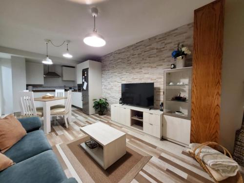 - un salon avec un canapé bleu et une table dans l'établissement Alojamiento en Villamayor, à Villamayor