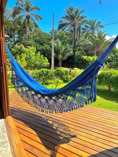 a blue hammock on a deck with palm trees at Oceà Privilegi - Taipu de Fora in Barra Grande