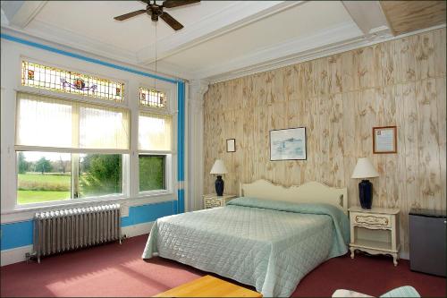 a bedroom with a bed and two windows at The Presidential Inn at Poland Spring Resort in Poland