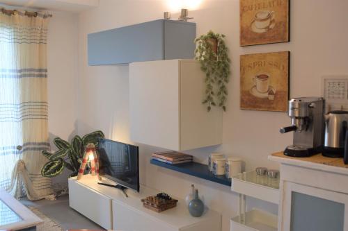 Calilla Home-appartamento Scirocco في غرادو: مطبخ مع كونتر مع تلفزيون وآلة صنع قهوة
