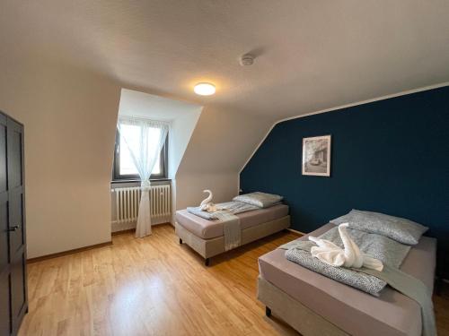 um quarto com 2 camas e uma parede azul em Comfortable Shared Apartment with Private Room in Wesseling em Wesseling