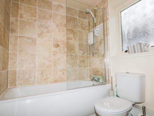 a bathroom with a tub and a toilet and a sink at The Old Mill in Beauly