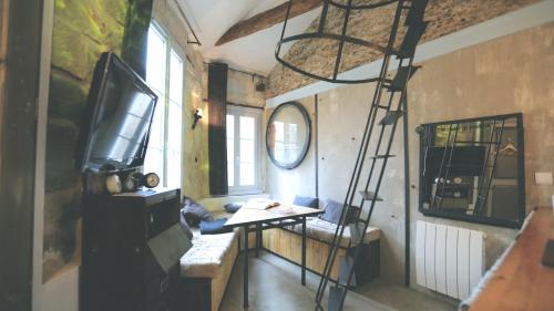 een kamer met een tv en een ladder in een kamer bij Surprenantes - Voyage en Ballon in Nantes