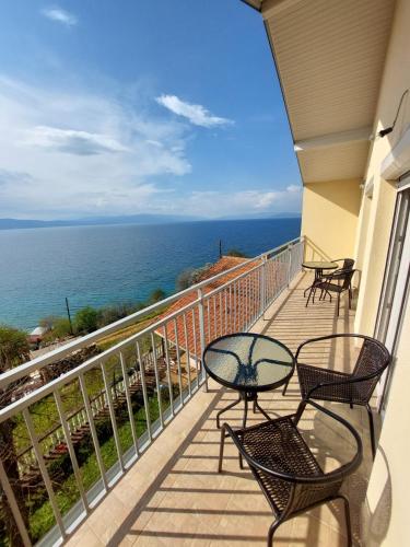a balcony with chairs and tables and the ocean at Indijano Apartment in Ohrid