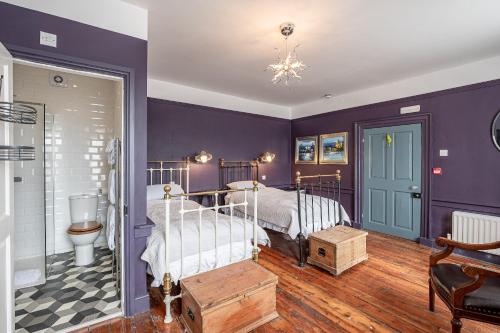 SkinningroveにあるMoonfleet Boutique Hotelの紫の壁のベッドルーム1室(ベッド1台付)