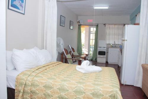 a bedroom with a bed with a towel on it at Buttercup Cottage Apartments in Arnos Vale