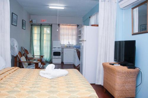 a bedroom with a bed with a white towel on it at Buttercup Cottage Apartments in Arnos Vale