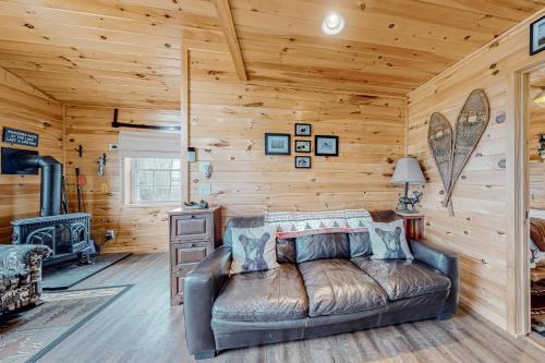 - un salon avec un canapé en cuir dans une cabane en rondins dans l'établissement Lake Adventures, à Greenville