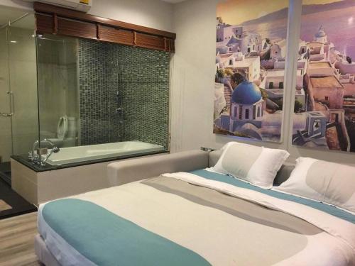 a bedroom with a large bed and a bath tub at The Crest Santora Huahin 4 Fl H(Monthly rate) in Hua Hin