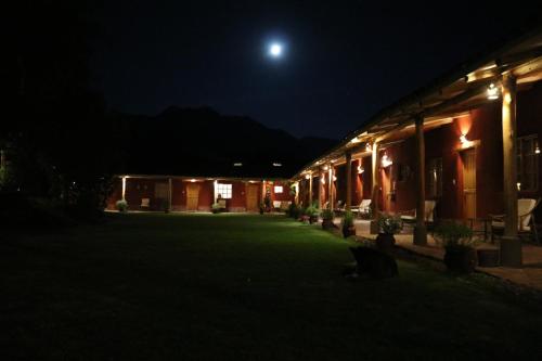 a house at night with the moon in the sky at Hotel Villa Urubamba in Urubamba