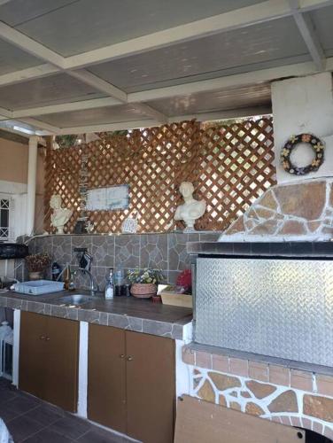 a kitchen with a sink and a stone wall at Villa View in Oropós