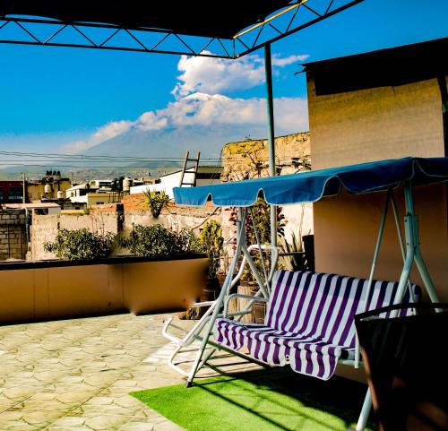 una silla y una sombrilla en el balcón en Posada de Belén, en Arequipa