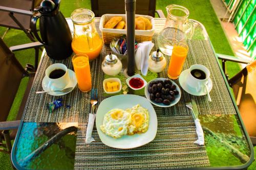 una mesa con un plato de desayuno y zumo de naranja en Posada de Belén, en Arequipa