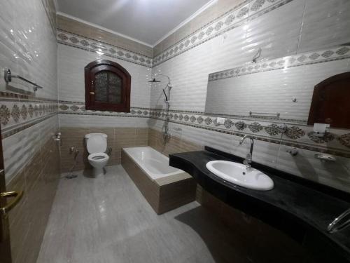 The royal flat for rent في Al Qurnah: حمام مع حوض وحوض استحمام ومرحاض