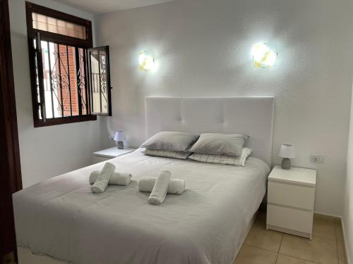 biała sypialnia z dużym białym łóżkiem z 2 poduszkami w obiekcie Under The Lime, beautiful apartment Los Cristianos w mieście Los Cristianos