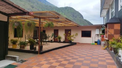 einen Innenhof mit Topfpflanzen vor einem Gebäude in der Unterkunft Casa vacacional Isai Hospedaje SPA in Baños