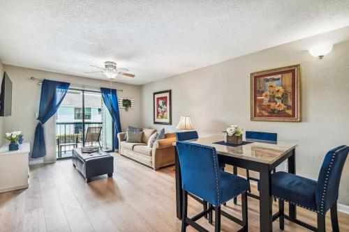 a living room with a dining room table and blue chairs at The Orchid by DNY Prime in Tampa