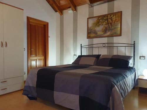 a bedroom with a bed with a black and gray comforter at Roccetta Fiorita in Pettenasco