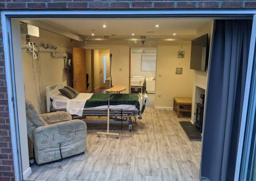 a hospital room with a bed and a couch at Family house with ceiling hoist & wet room in Bishops Tachbrook