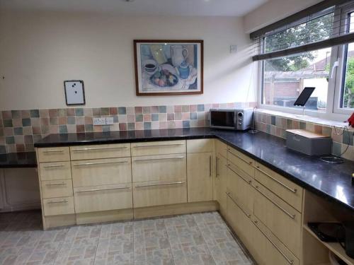 a kitchen with a black counter top and a window at Family house with ceiling hoist & wet room in Bishops Tachbrook