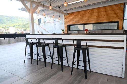 a bar with black stools in a kitchen at Puy Castele Hotel Tiberias in Tiberias