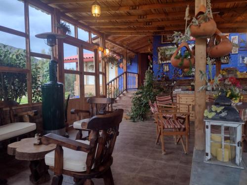 Casa Campestre EL CAPRICHO Fúquene في Fúquene: مطعم فيه كراسي وطاولات خشبية ونوافذ