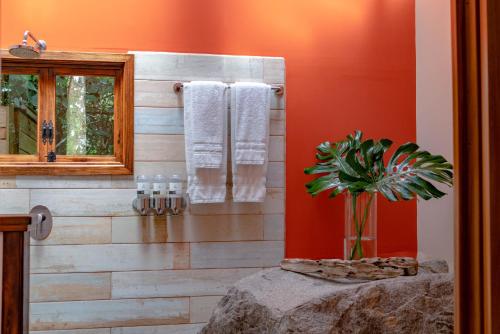 a bathroom with a wooden wall with towels at Rio Chirripo in Rivas