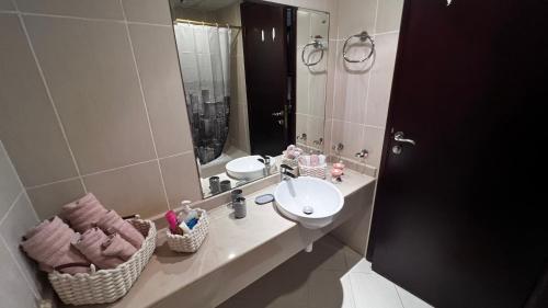 a bathroom with a sink and a mirror at Stunning high floor Ocean front Retreat with Panoramic Sea Views for Rent in Ras al Khaimah