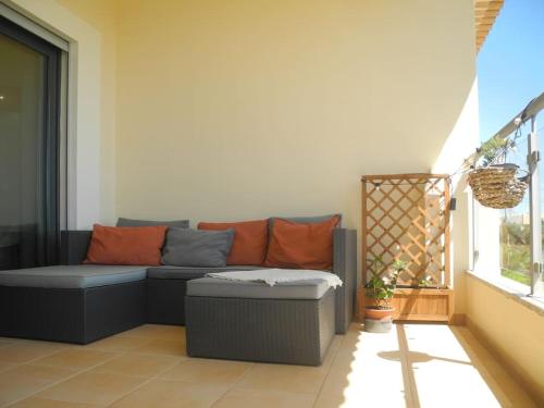 a living room with a couch on a patio at Panorama Apartment Sagres *Pool* in Sagres