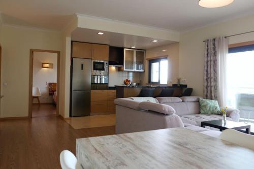 a living room with a white couch and a kitchen at Panorama Apartment Sagres *Pool* in Sagres