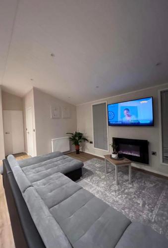 a living room with a couch and a flat screen tv at Family home in Northampton