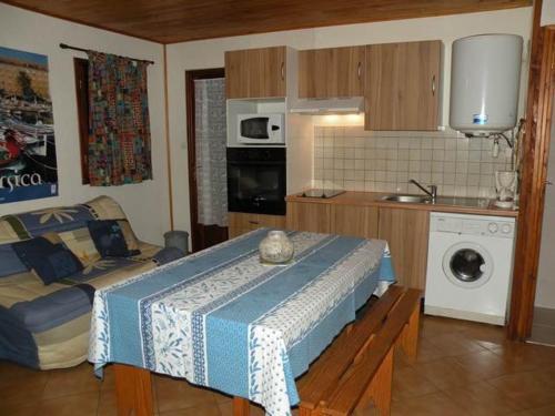 Habitación con cocina con cama y mesa. en Gites Chalets de Grosseto-Prugna, en Grosseto-Prugna