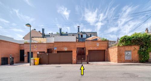 a brick building with a yellow sign in the street at A CASACAFÉ Madrid Pozuelo Estación Private Rooms in Pozuelo de Alarcón