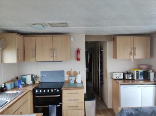 a kitchen with wooden cabinets and a black stove top oven at Seaview C29 in Hartlepool