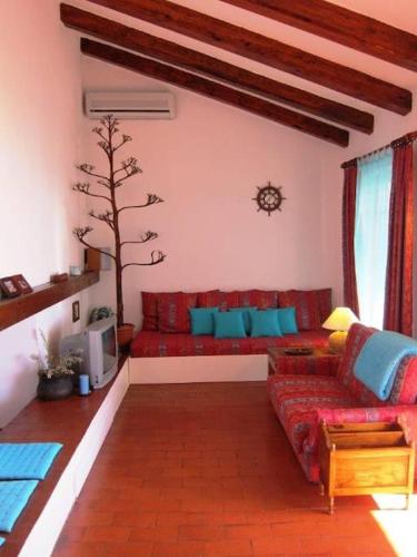 a living room with a red couch and a tree at House by the sea in Podaca