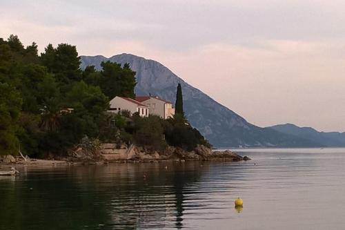 a house on an island in a body of water at House by the sea in Podaca