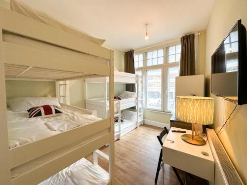 a dorm room with bunk beds and a desk and a bed at Pink Door Guesthouse in London
