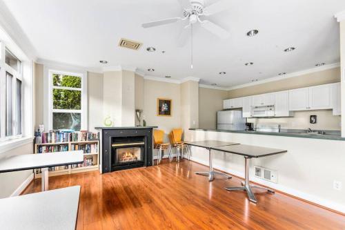 a living room with a fireplace and a kitchen with tables at Corner Unit in the middle of it all - 99 Walkscore in Seattle