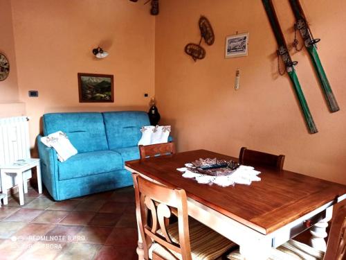 uma sala de estar com um sofá azul e uma mesa em Casa Coccinella Valdieri - Codice CIR00423300008 em Valdieri