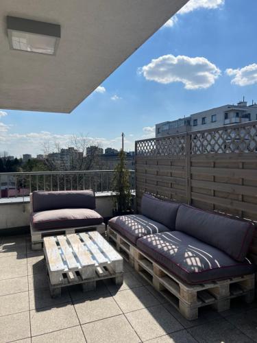 a patio with two couches and a table on a balcony at Apartament Księcia Janusza in Warsaw