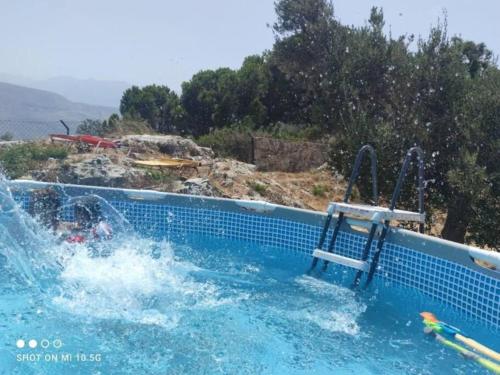 a swimming pool with a water slide at Όμορφο διαμέρισμα με θέα in Korakiaí