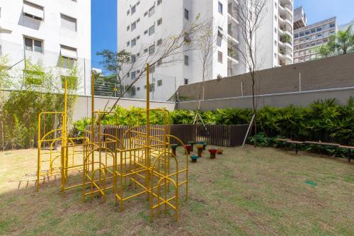 a playground with yellow metal swings in a park at Studio Luxo Itaim - Homax in Sao Paulo