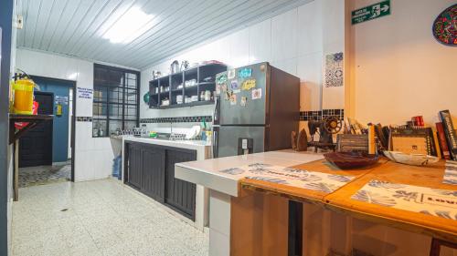 a kitchen with a refrigerator and a counter top at Tambo Hostel in Leticia