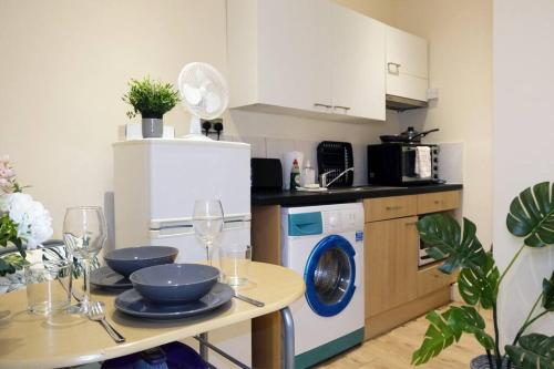 a kitchen with a table with a washing machine at LFC Stadium Apartment 2 in Liverpool