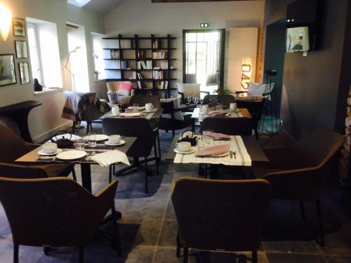 a restaurant with tables and chairs in a room at Manoir des Eperviers in Quéven
