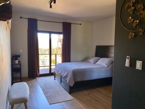 a bedroom with a bed and a sliding glass door at Coquenas del Valle in Valle de Guadalupe