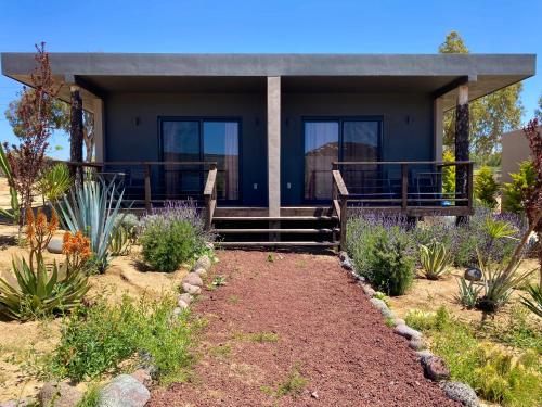 a house with a porch and some plants at Coquenas del Valle in Valle de Guadalupe