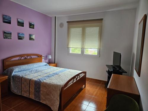 Dormitorio con cama, escritorio y TV en Apartamento en Laxe, Costa da Morte, en Laxe